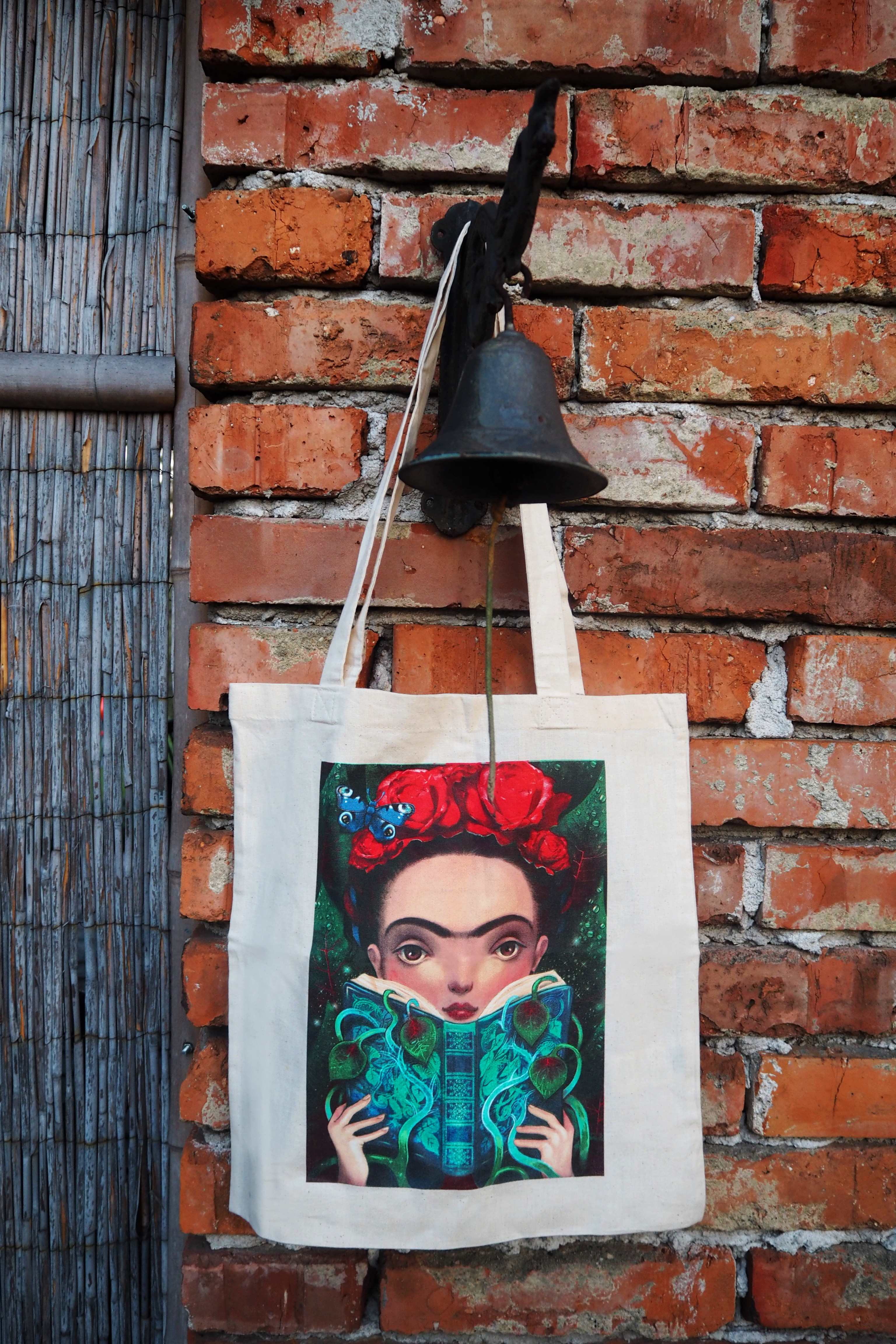 Plátěná taška s barevným vyobrazením Fridy Kahlo. Z druhé strany nápisy.